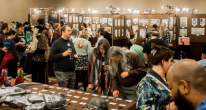 Attendees at a past Arisia art show browse art on display.